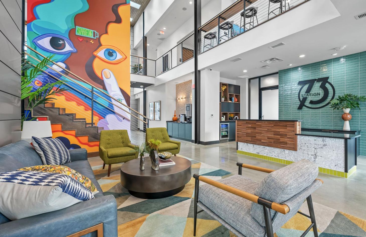 Vibrant and stylish lobby area with colorful mural, modern seating, and a reception desk.